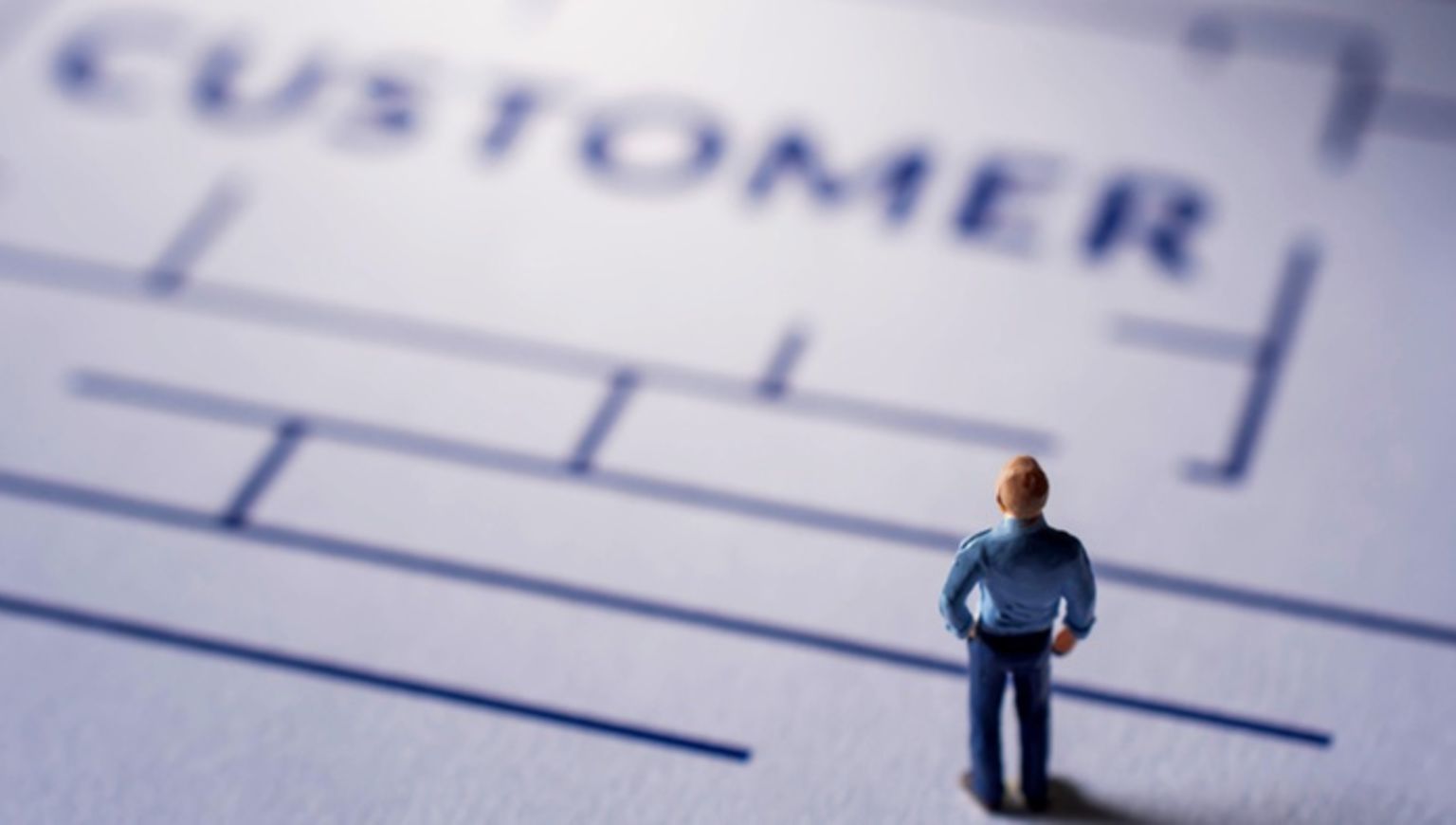 A miniture figurine man on a paper maze.