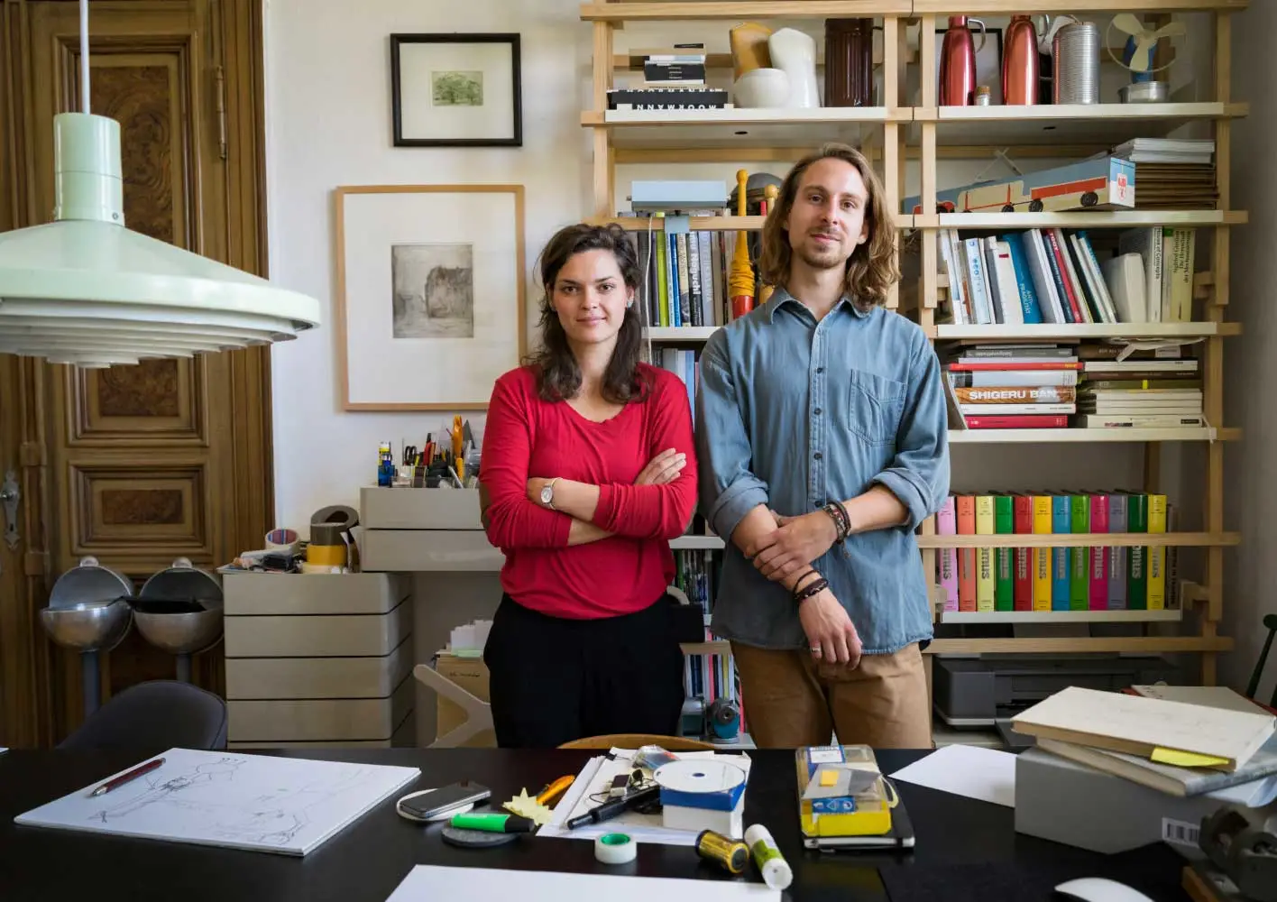 A businessman and businesswoman standing behind a desk in home office