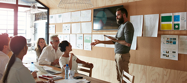 Man leading an in-person workshop with a team of people