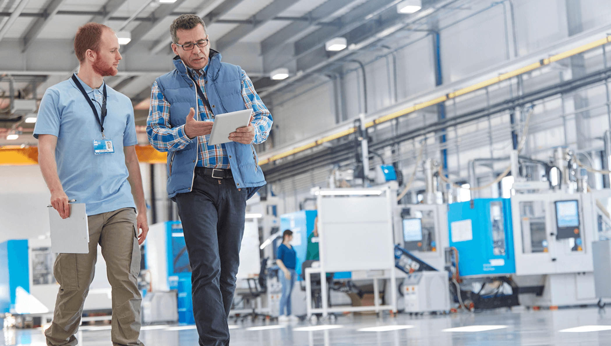 Image of two people walking in a modern factory